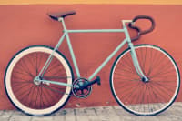 bicycle resting against an orange wall