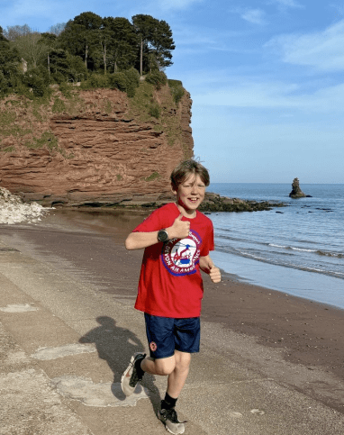 A young fundraiser running Devon's coastline