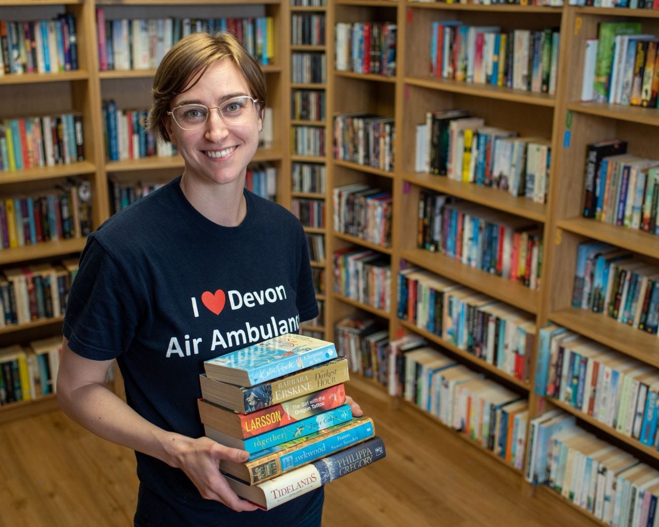 A young volunteer stacks books in our shop